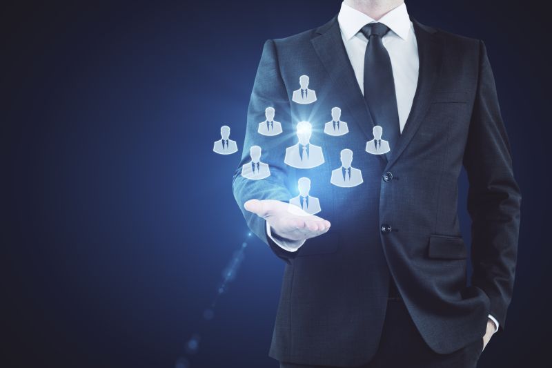 Businessman Holding Hr Hologram On Dark Background. Employer Concept