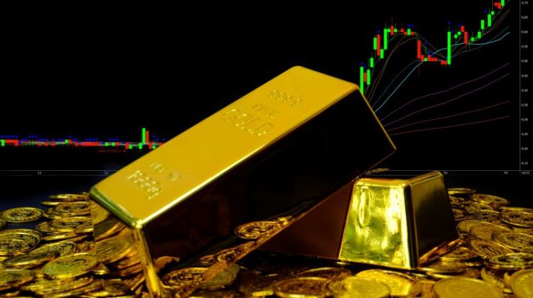 Gold bullion on pile gold coins at trading chart background