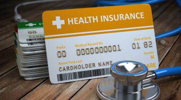 Health care medical Insurance card and stethoscope as a symbol of medicine on the wood background.