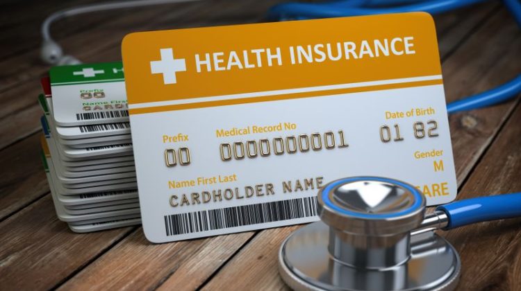 Health care medical Insurance card and stethoscope as a symbol of medicine on the wood background.