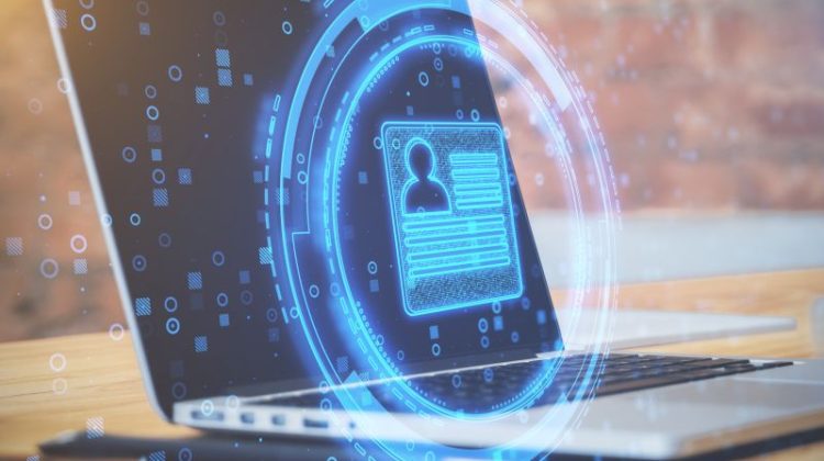 Close Up Of Desktop With Laptop And Abstract Glowing Digital Profile On Blurry Office Background