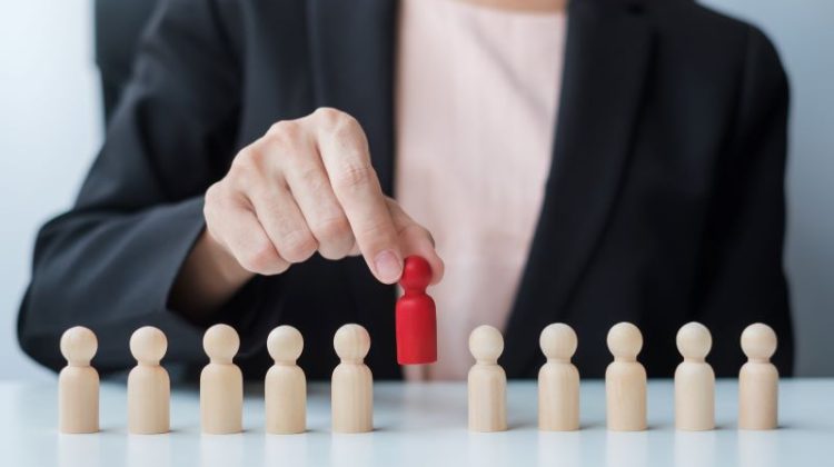 Businesswoman hand pulling leader man wooden from crowd of employees. Toxic People, Human resource management, Recruitment, Teamwork and leadership Concepts