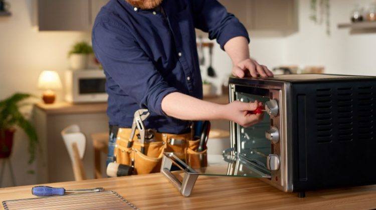 Man Repairing Toaster Oven in Kitchen