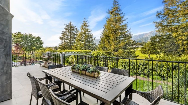 Deck with outdoor dining set overlooking scenic vineyard
