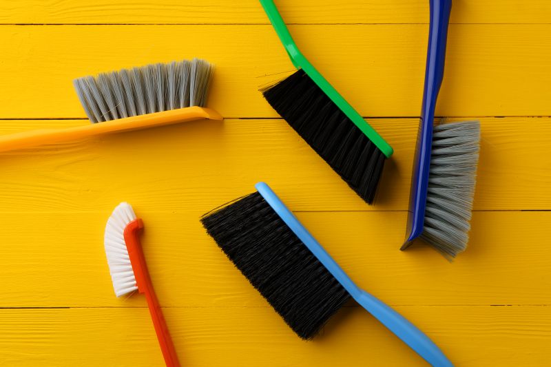 Colorful Cleaning Brushes on a Bright Yellow Background