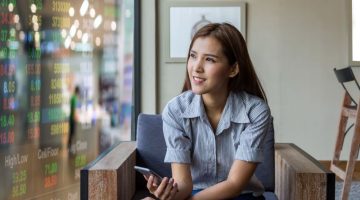 Thoughtful Woman Relaxing in Armchair with Phone