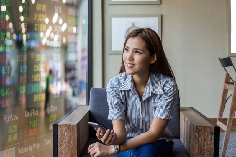 Thoughtful Woman Relaxing in Armchair with Phone
