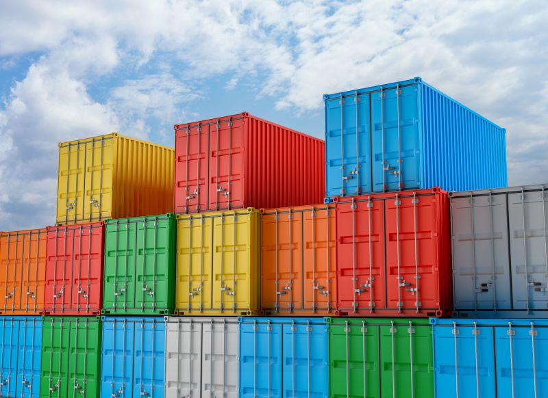 Shipping Containers Stacked Under a Cloudy Blue Sky