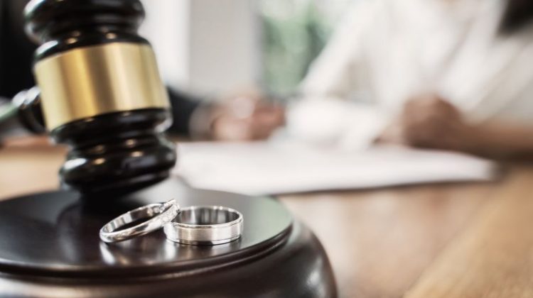 Divorce concept with gavel and wedding rings
