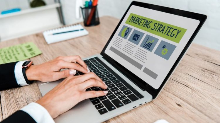 Hands Typing on Laptop Displaying Marketing Strategy
