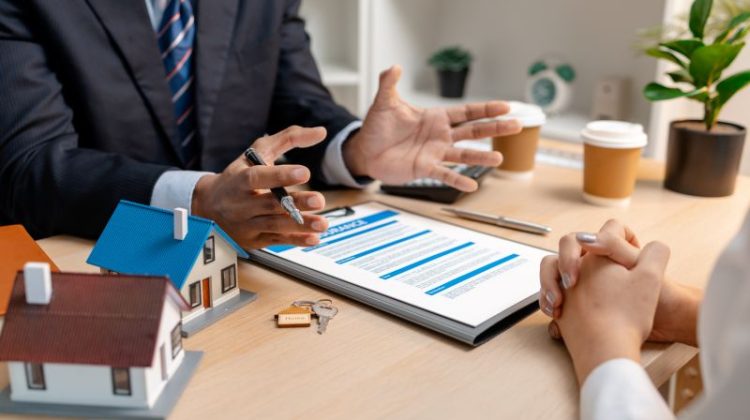 A real estate agent explains home insurance details to a client