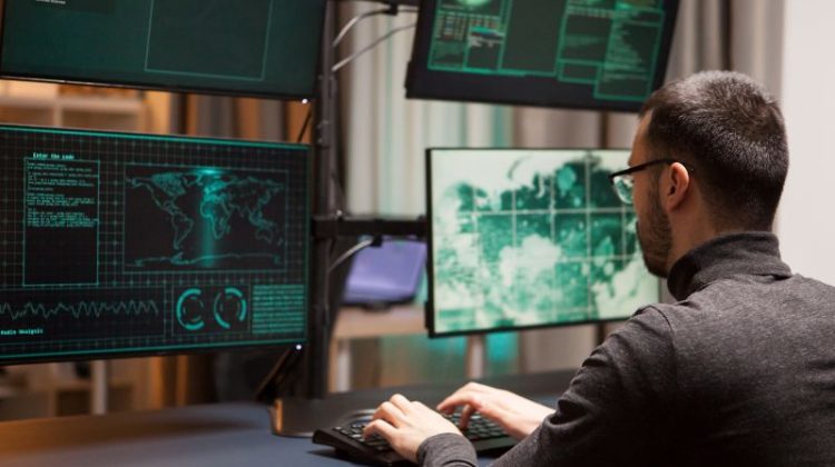 Man Coding on Multiple Monitors at Workplace