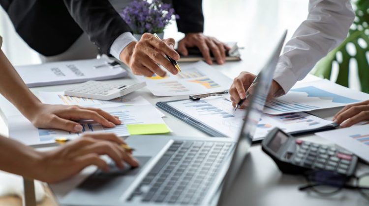 business people meeting in the office Calculate the tax and income of the company's investment.