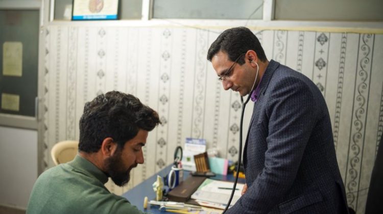 A doctor uses a stethoscope for a patient's health check-up in a clinic