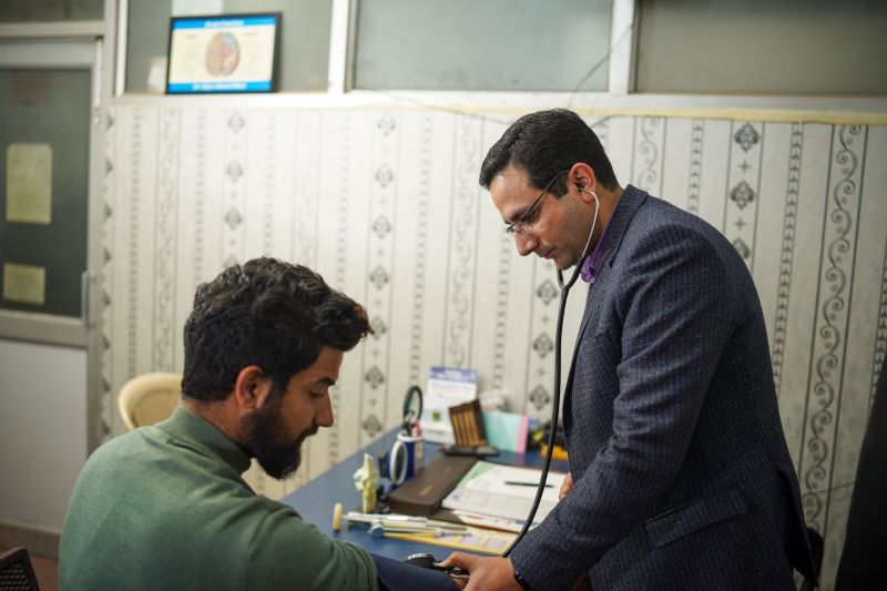 A doctor uses a stethoscope for a patient's health check-up in a clinic