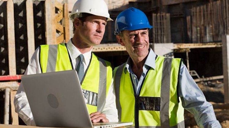 Construction Workers Reviewing Plans at Construction Site