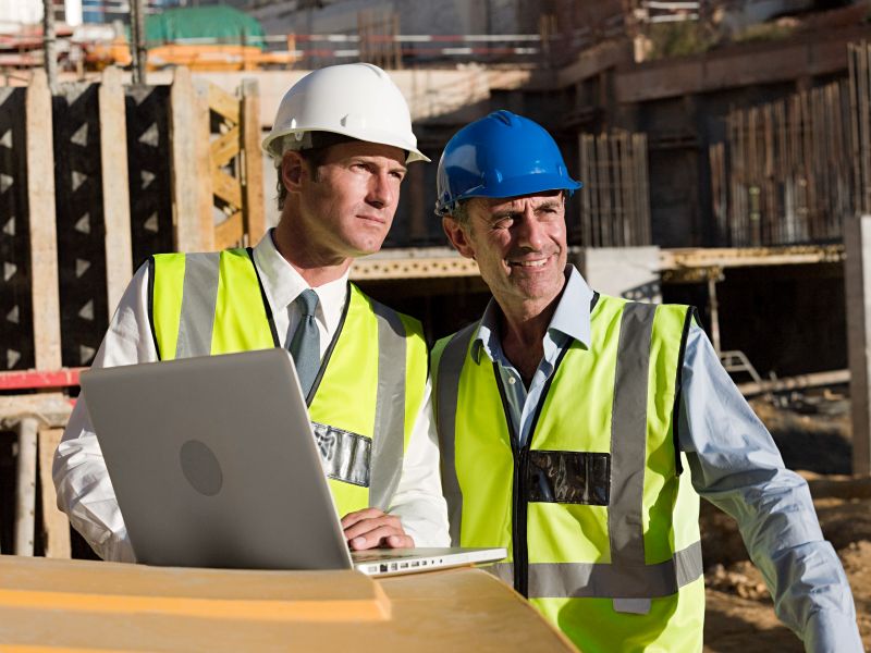 Construction Workers Reviewing Plans at Construction Site