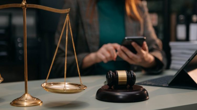 Woman Lawyer Using Mobile Phone with Gavel and Scales