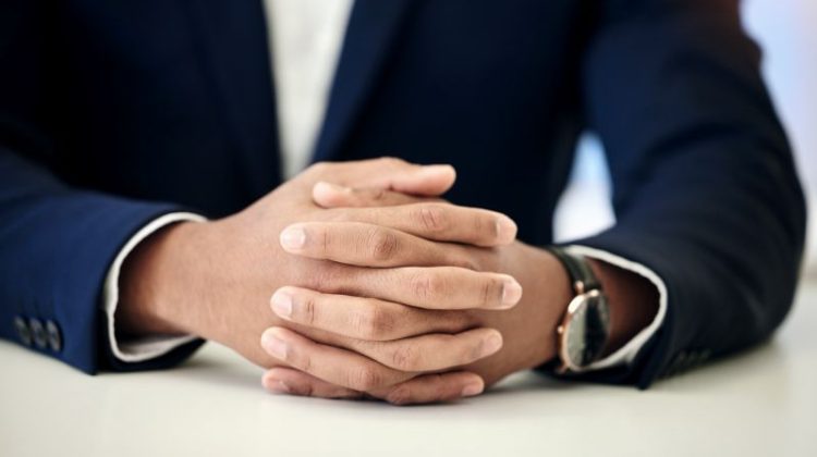 Hands Clasped on Desk in Business Attire
