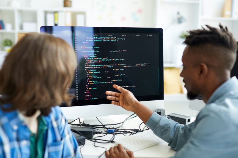 Software Developers Discussing Code at Workplace