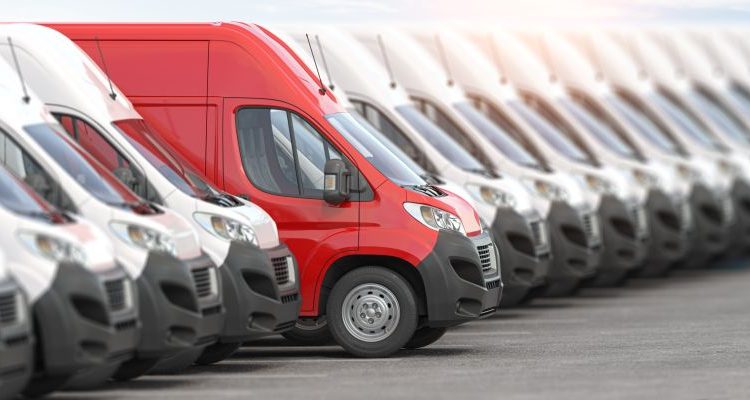 Red delivery van in a row of white vans. Best express delivery and shipemt service concept.