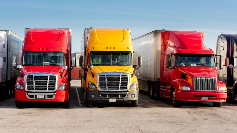 Three Semi Trucks Parked in an Urban Lot