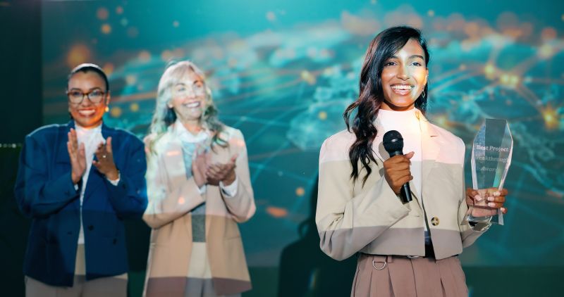 Award Presentation with Women Applauding on Stage