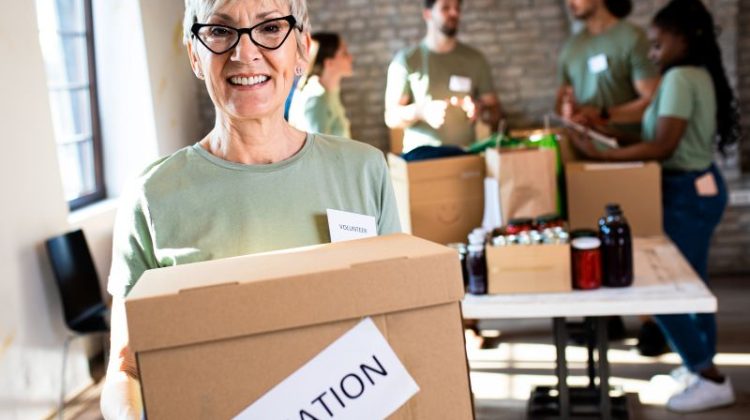 Group of volunteers with working in community charity donation center.