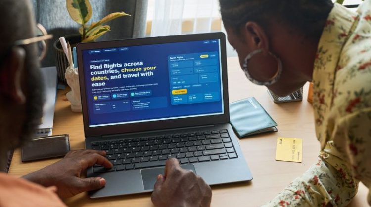 Couple Planning International Trip on Laptop at Home Table