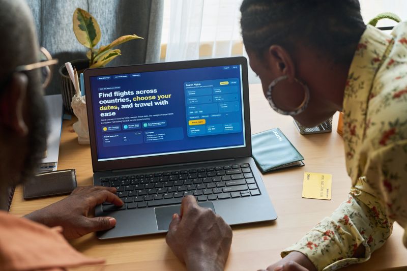 Couple Planning International Trip on Laptop at Home Table