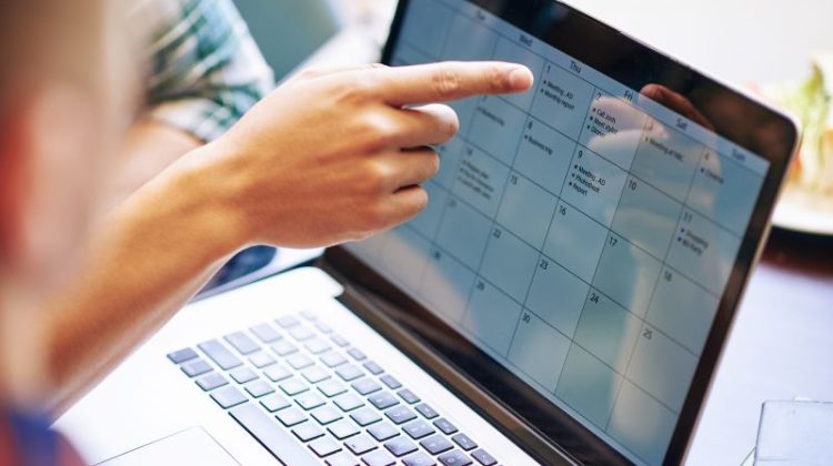 Man Planning Business Calendar on Laptop Computer