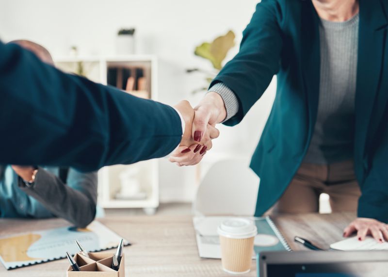 Professional Handshake Between Two Individuals in an Office