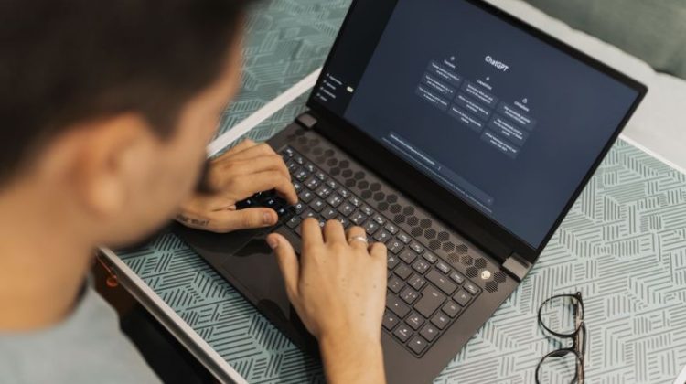 A man working on a laptop with AI software open on the screen.
