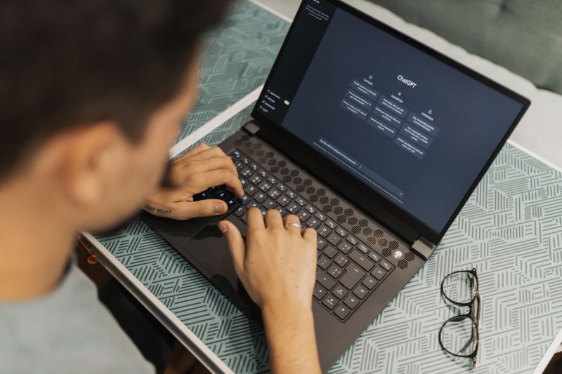 A man working on a laptop with AI software open on the screen.