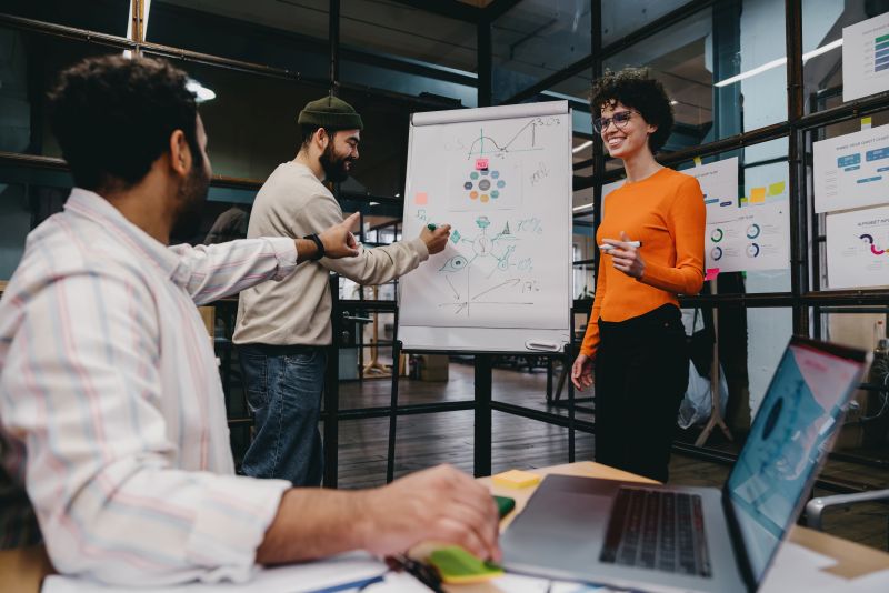 Group of cheerful colleagues discussing project in office
