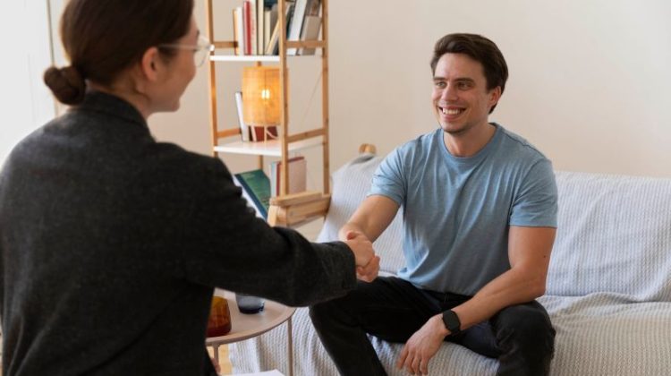 Mental health professional greeting a smiling patient during a consultation.