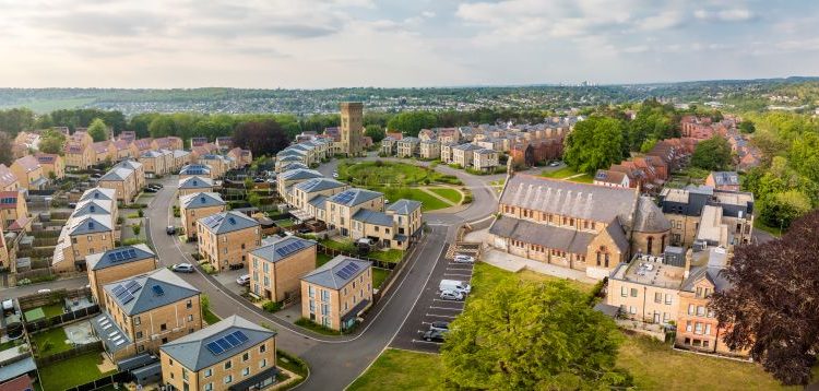 Aerial view of housing development and green space in England.