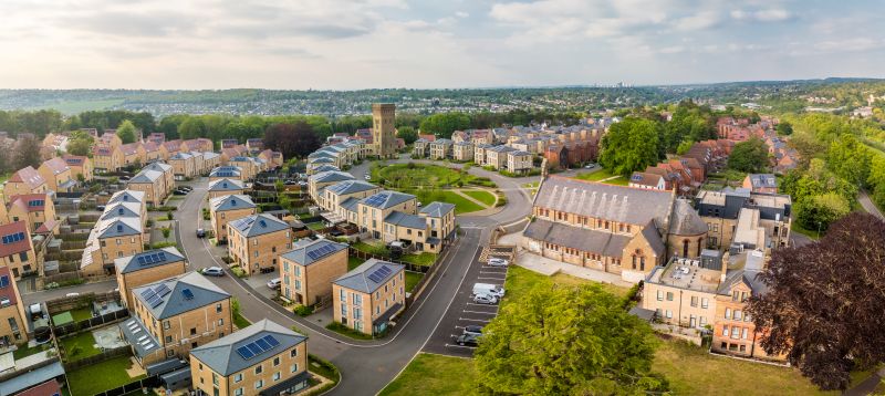 Aerial view of housing development and green space in England.