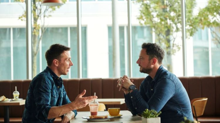 Two small business owners having a networking conversation over coffee in a café