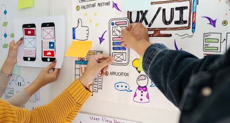 UX/UI designers collaborating on mobile interface wireframes and user experience concepts.