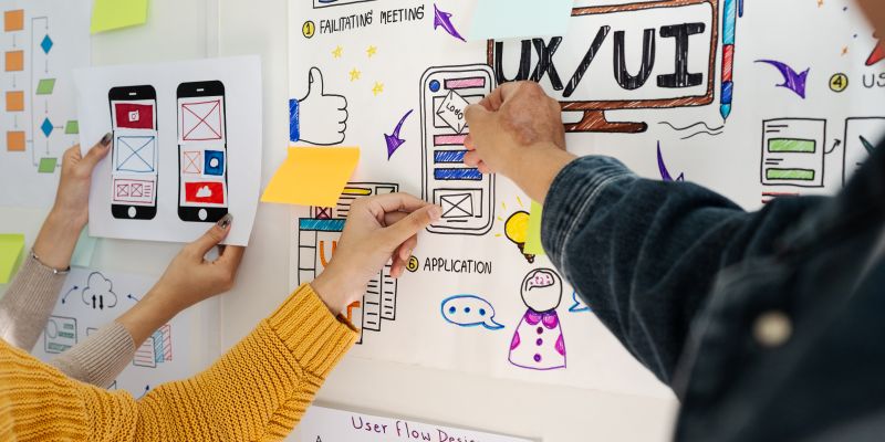 UX/UI designers collaborating on mobile interface wireframes and user experience concepts.
