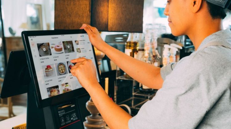 Employee using a digital ordering system to manage purchases in a hospitality business