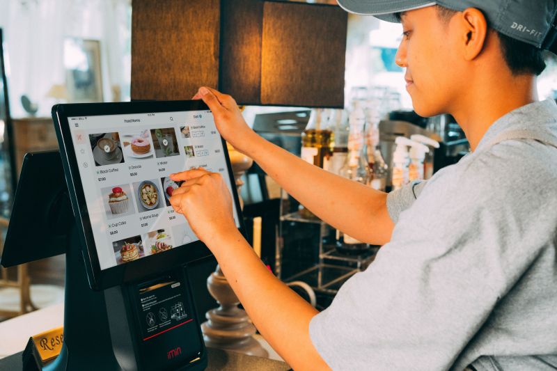 Employee using a digital ordering system to manage purchases in a hospitality business
